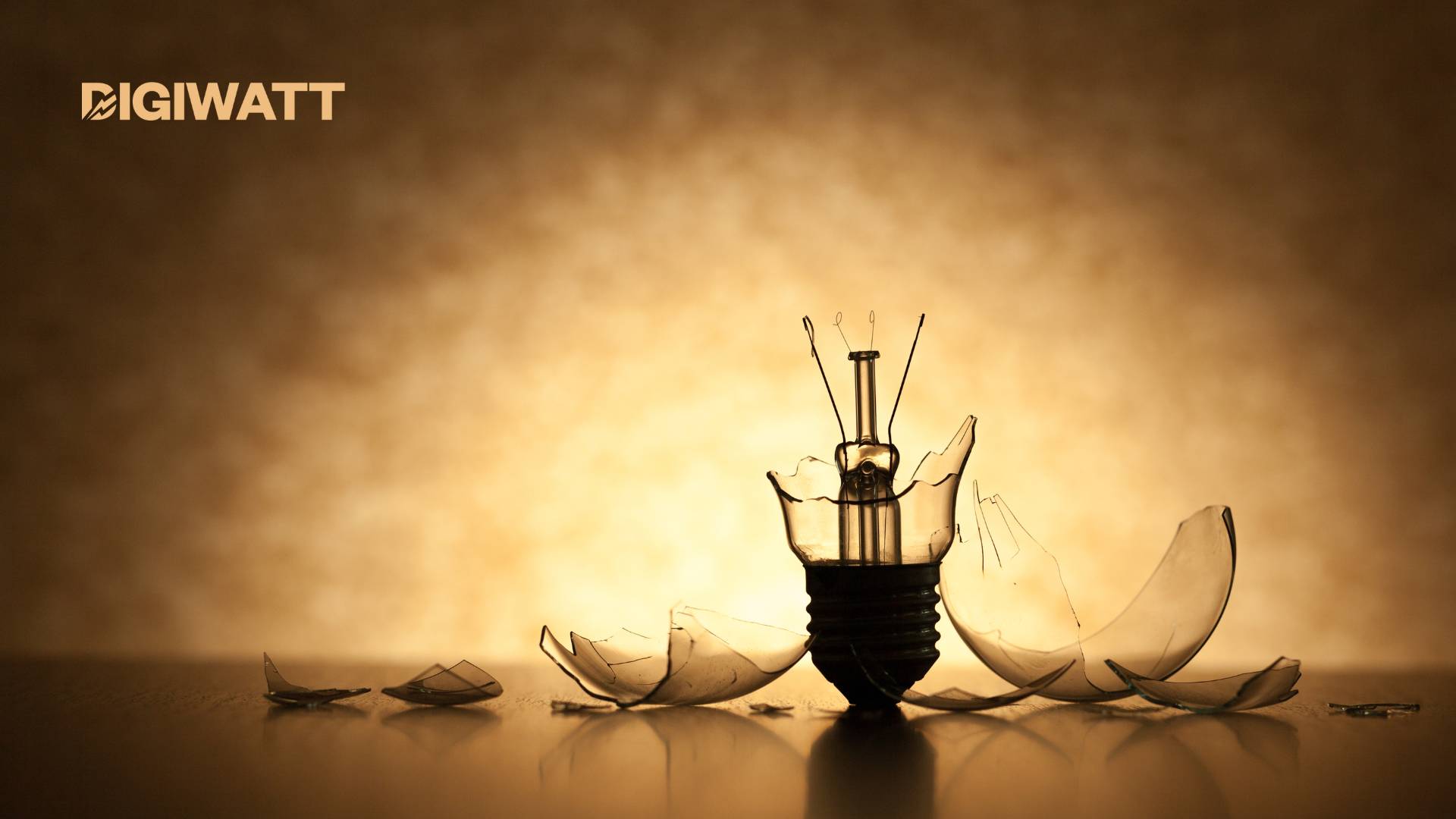 Lampadina rotta con vetri in frantumi su fondo caldo; logo Digiwatt in alto a sinistra
